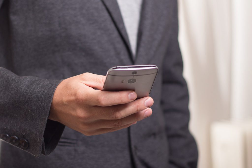 a man holding a cell phone, representing messaging on linkedin